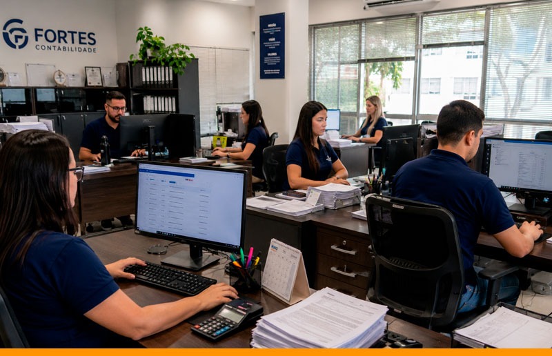 Profissional administrativo organizando processos de emissão fiscal em ambiente corporativo, utilizando sistema de gestão para controlar documentos fiscais, evitar erros operacionais e aumentar a produtividade do escritório.